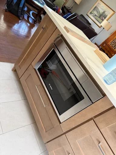 Island cabinetry being fitted around an integrated microwave drawer